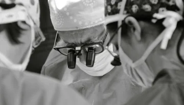 Cirurgião vascular utilizando lupas de magnificação para garantir máxima precisão em procedimento de alta complexidade.