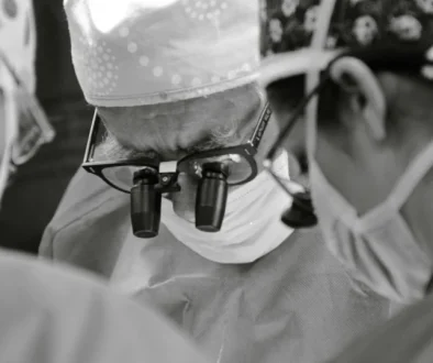 Cirurgião vascular utilizando lupas de magnificação para garantir máxima precisão em procedimento de alta complexidade.